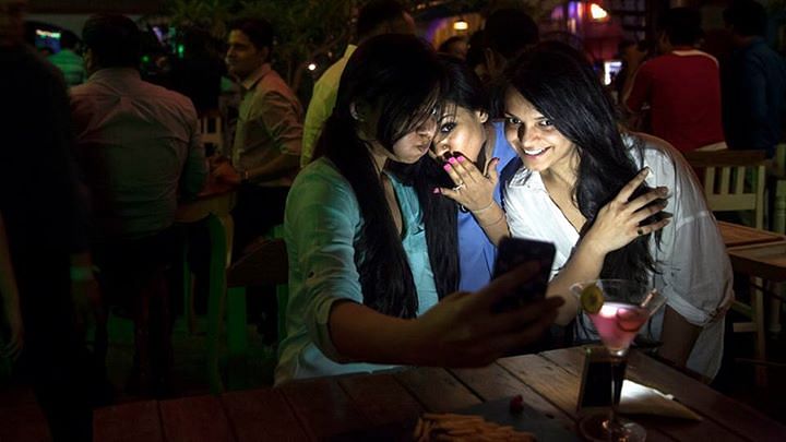  ‘ट्रूली मैडली’ द्वारा आयोजित पार्टी में सेल्फी लेती युवतियाँ (फोटो : एपी)