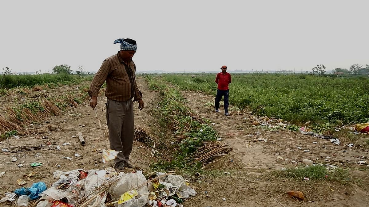 विश्व सांस्कृतिक महोत्सव के बाद गंदगी और मल-मूत्र से भरे  खेतों को खुद ही साफ करने को मजबूर हैं किसान.