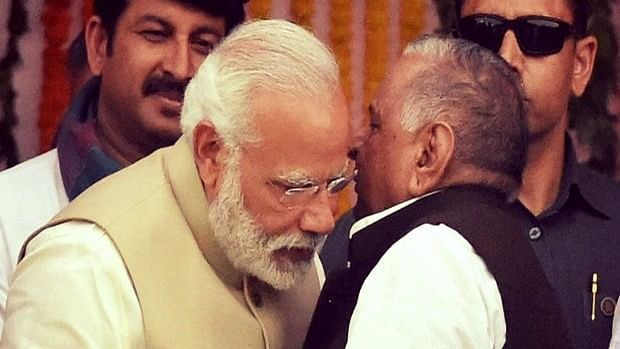 पीएम मोदी की कान में कुछ कहते हुए मुलायम सिंह (फोटोः PTI)