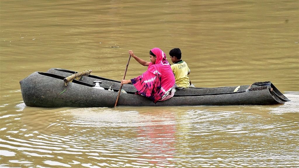 

पश्चिम बंगाल: पश्चिम मिदनापुर जिले के घाटल में नाव पर सवार एक महिला और बच्चा