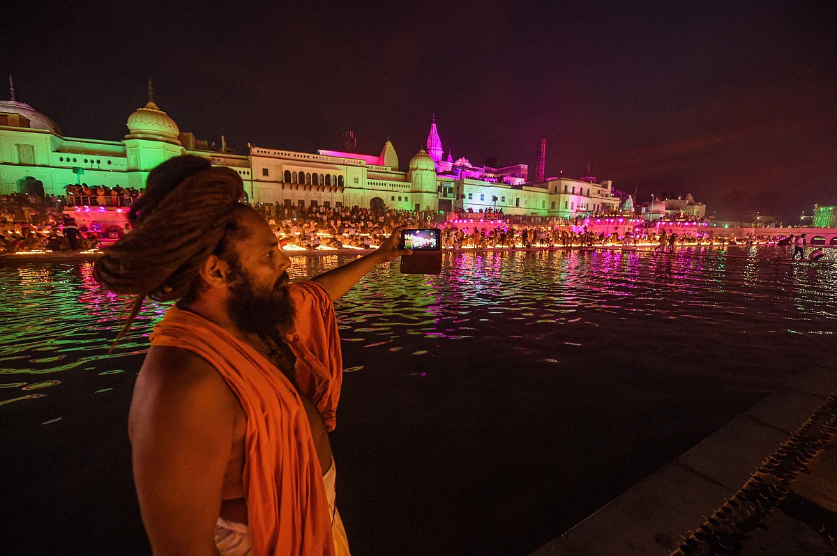 दीपोत्सव समारोह में सरयू नदी के तट पर सेल्फी लेता एक साधु