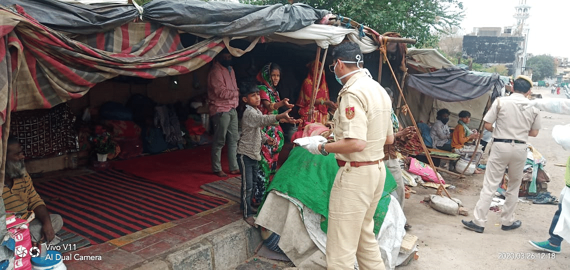 दिल्ली पुलिस के अधिकारी अन्य लोगों के साथ मिलकर कर रहे खाना बांटने का काम