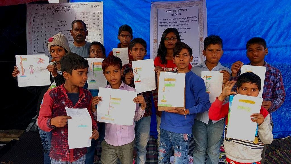 सावित्री बाई फुले पाठशाला में तिरंगा बनाकर दिखाते बच्चे