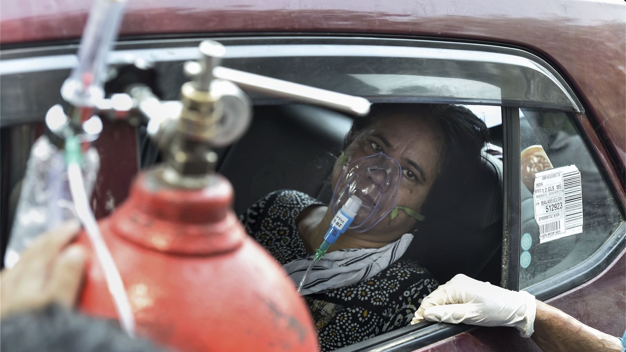 दिल्ली के एलएनजेपी अस्पताल के बाहर इंतजार करती एक मरीज, 2 मई 2021 की तस्वीर