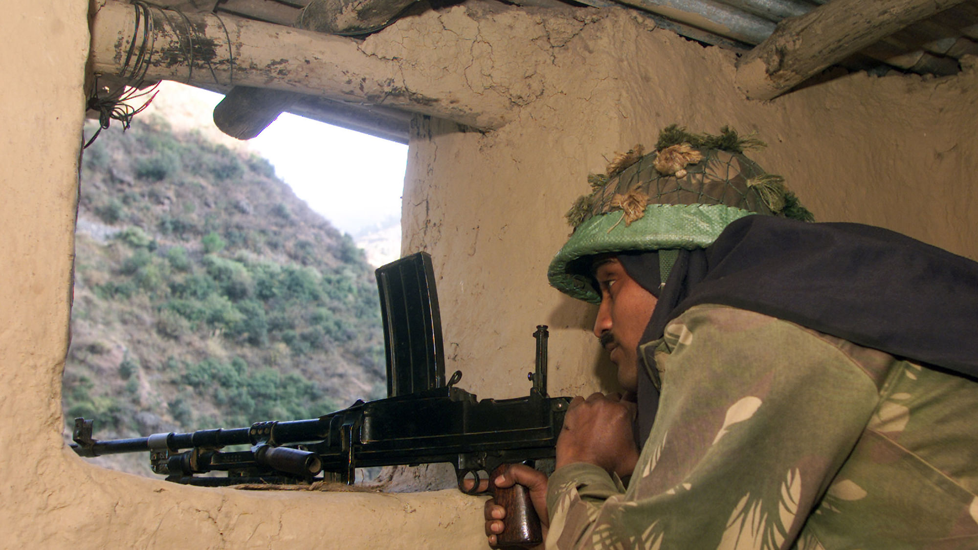 An Indian army soldier mans a gun inside his bunker.&nbsp;