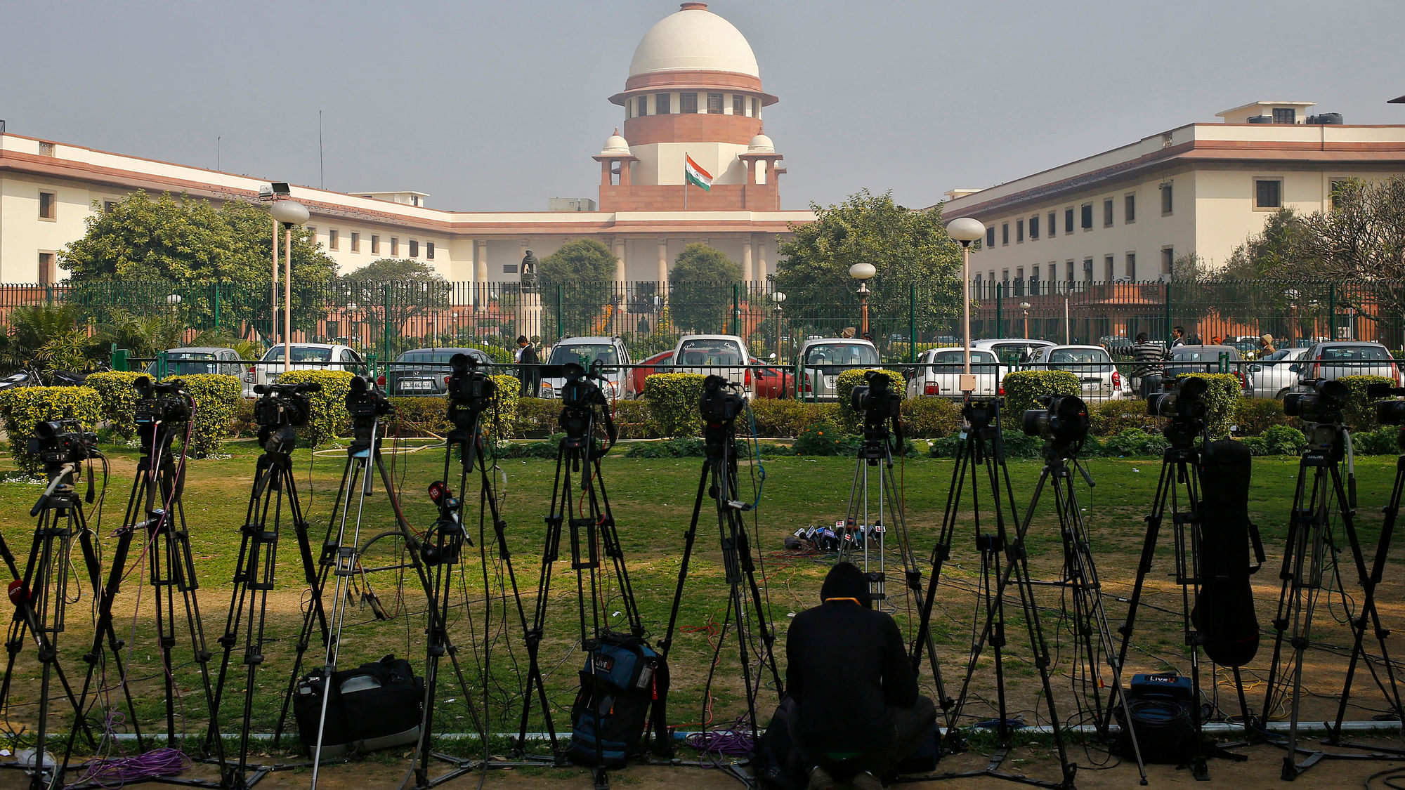 A cameraman sits near a row of cameras&nbsp;inside the premises of the Supreme Court in New Delhi. (Photo: Reuters)