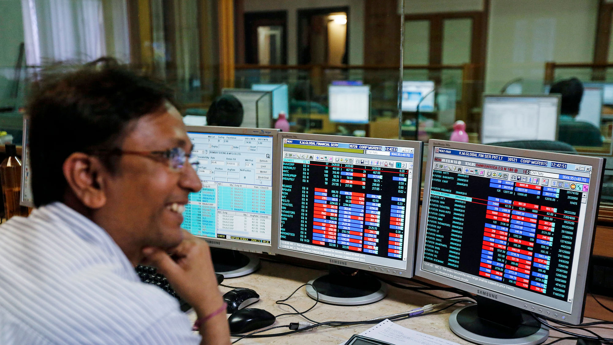  A broker laughs while speaking to a colleague, as they trade on their computer terminals at a stock brokerage firm in Mumbai, 4 March  2015.&nbsp;