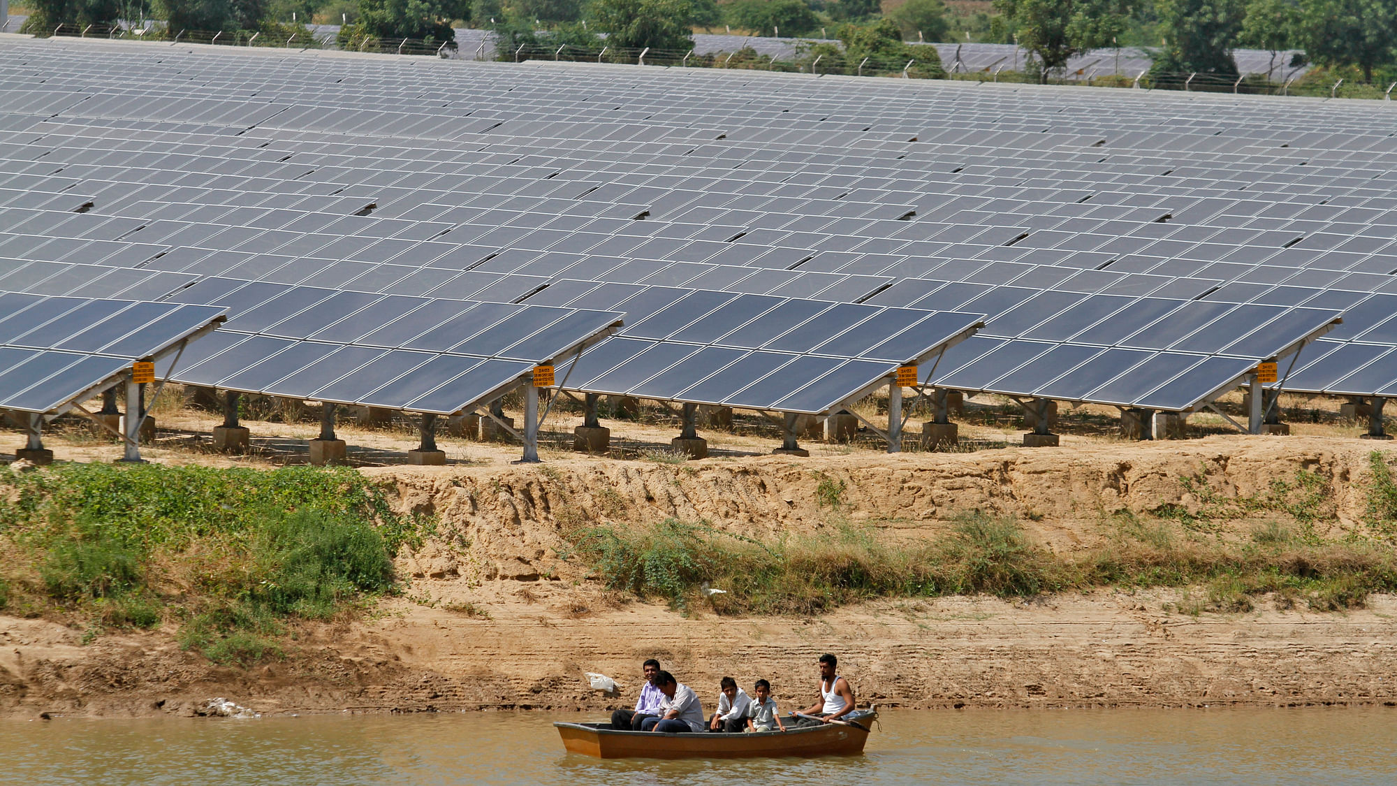 

Security personnel sit in a boat as they patrol the premises of solar farm in Gujarat.&nbsp;