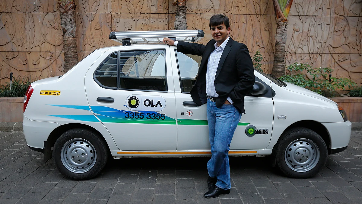 Bhavish Aggarwal, CEO and co-founder of Ola, an app-based cab service provider, poses in front of an Ola cab in Mumbai 3 March 2015. (Photo: Reuters)