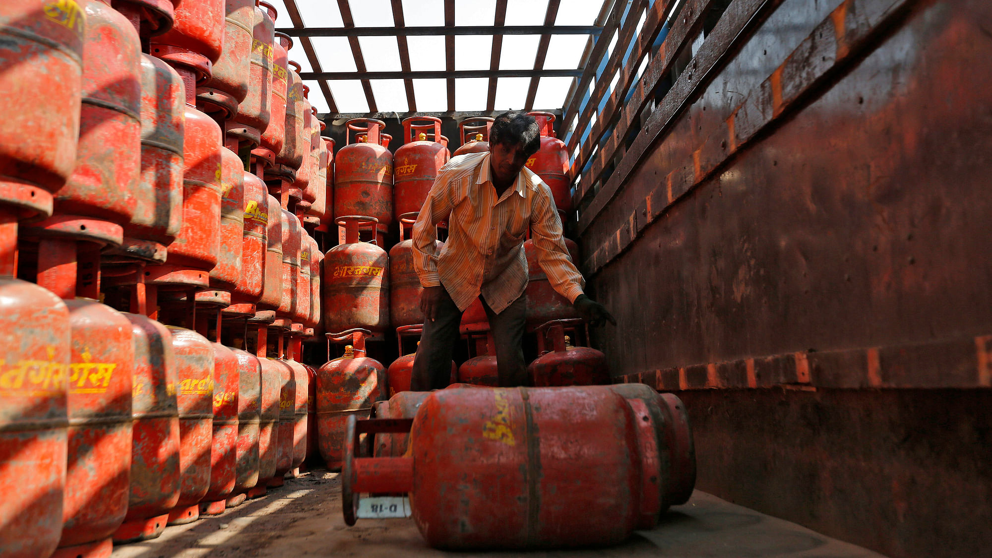  A worker unloads liquefied petroleum gas (LPG) cooking cylinders from a supply truck outside a distribution centre. Image used for representational purposes.