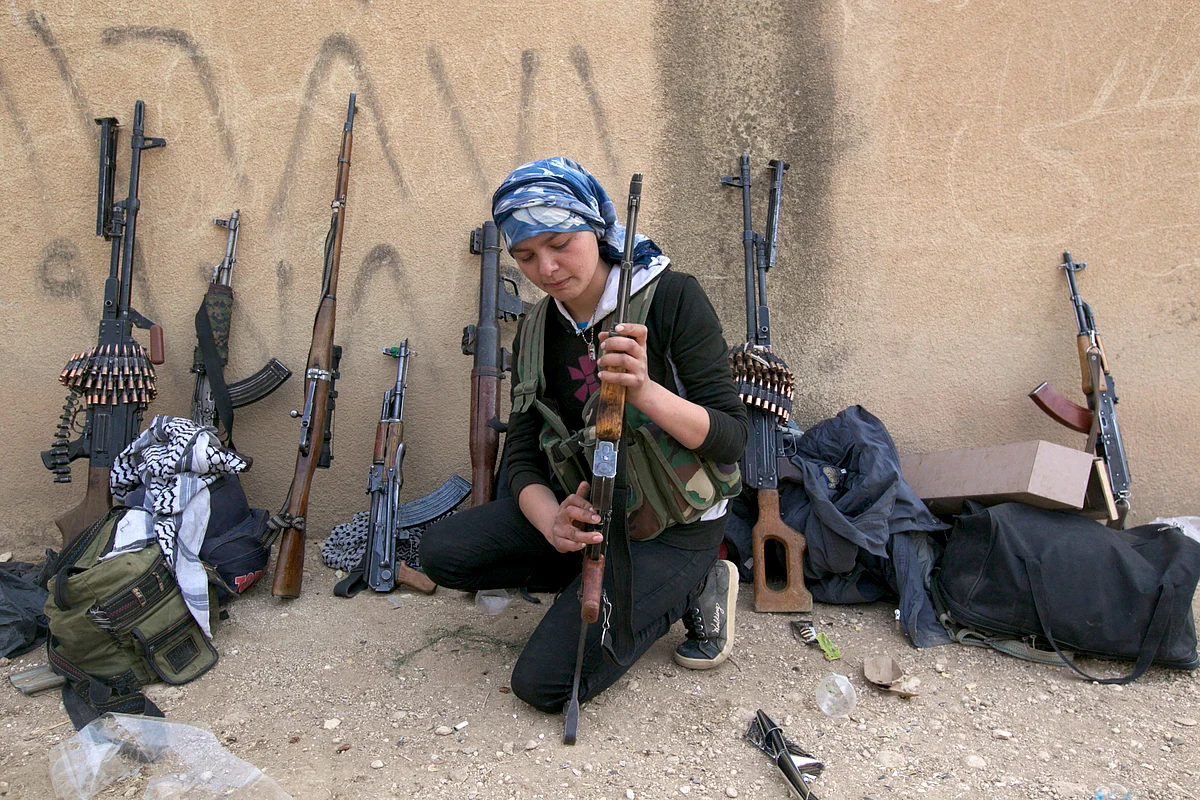 A Kurdish female fighter from Kurdish People’s Protection Units (YPG) checks her weapon near Ras al-Ain, in the province of Hasakah, after capturing it from Islamist rebels, November 6, 2013. (Photo: Reuters)<!--EndFragment-->