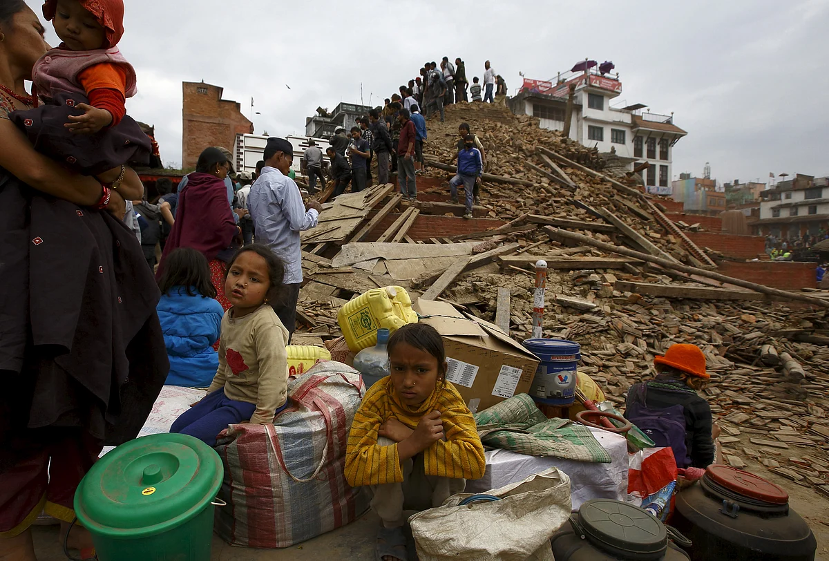 People sit with their belongings outside a damaged temple in Durbar Square after the earthquake hit Kathmandu (Photo: Reuters)
