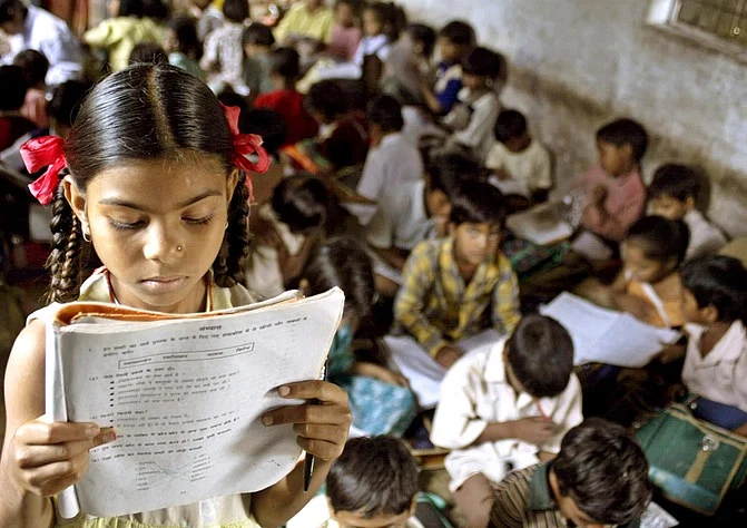 An Indian school girl reads her book inside her class at a government-run school. (Photo: Reuters)