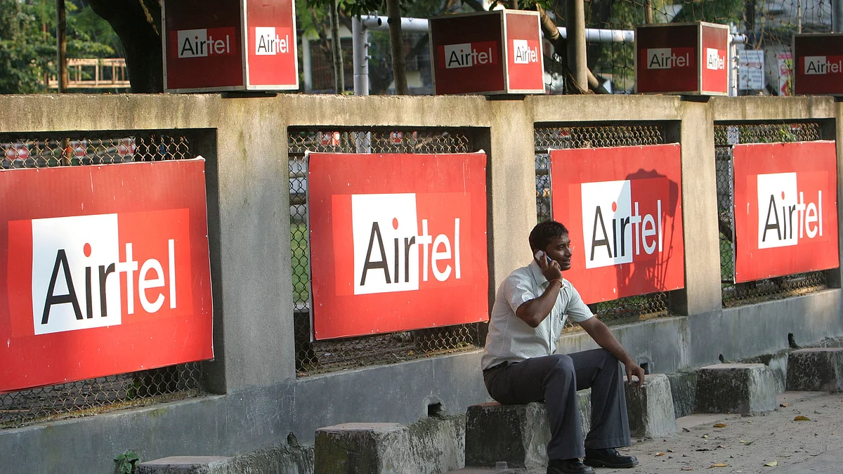 A man talks on a mobile phone in front of Bharti Airtel hoardings in the eastern Indian city of Siliguri. 