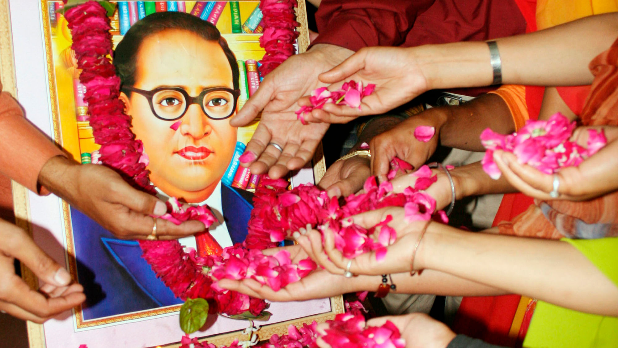 People scatter rose petals in front of a portrait of Dr BR Ambedkar, the author of the Indian Constitution.&nbsp;