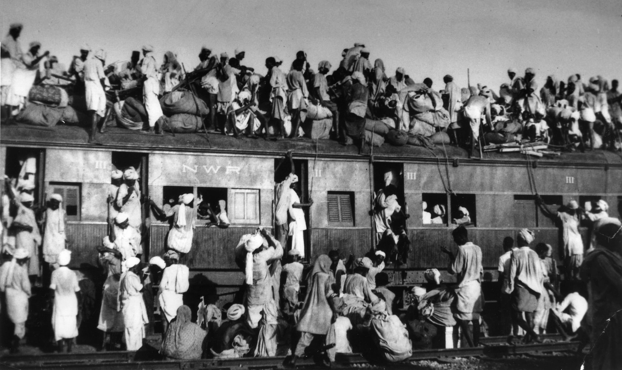 Muslim refugees sit on the roof of a railway coach near New Delhi&nbsp;trying to flee India. (Photo: AP)