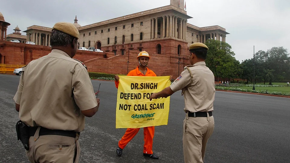 In this file photo, policemen prepare to remove a Greenpeace activist as he holds a banner near the Parliament. (Photo: AP)