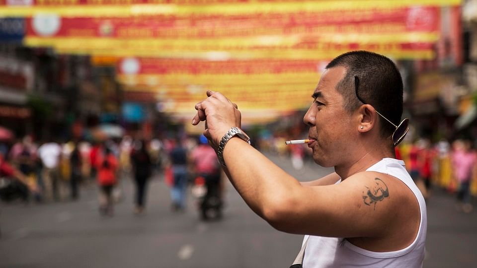 File image of a Chinese tourist with a tattoo of China’s late Chairman Mao Zedong taking pictures in Bangkok’s Chinatown decorated for the Chinese Lunar New Year in February 2015. (Photo: Reuters)