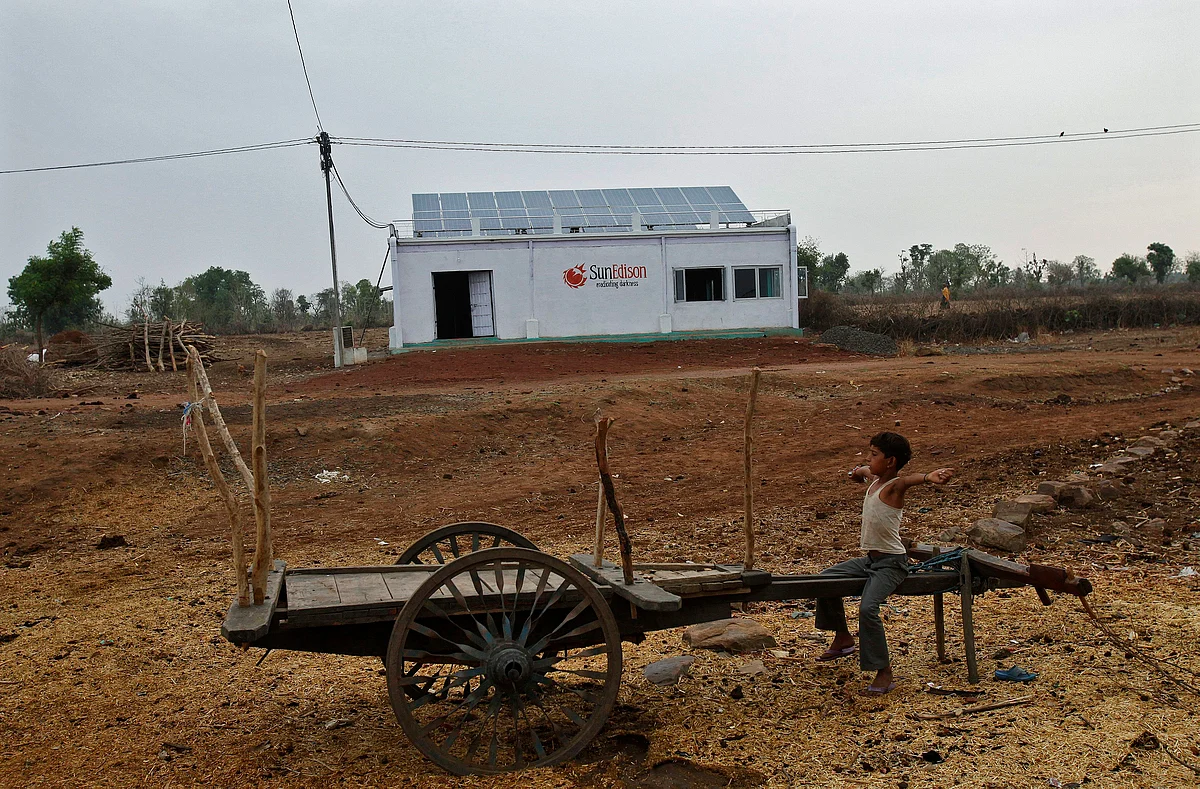 A boy sits on a cart in front of a solar power plant at Meerwada village of Guna district in the central Indian state of Madhya Pradesh. (Photo: Reuters)