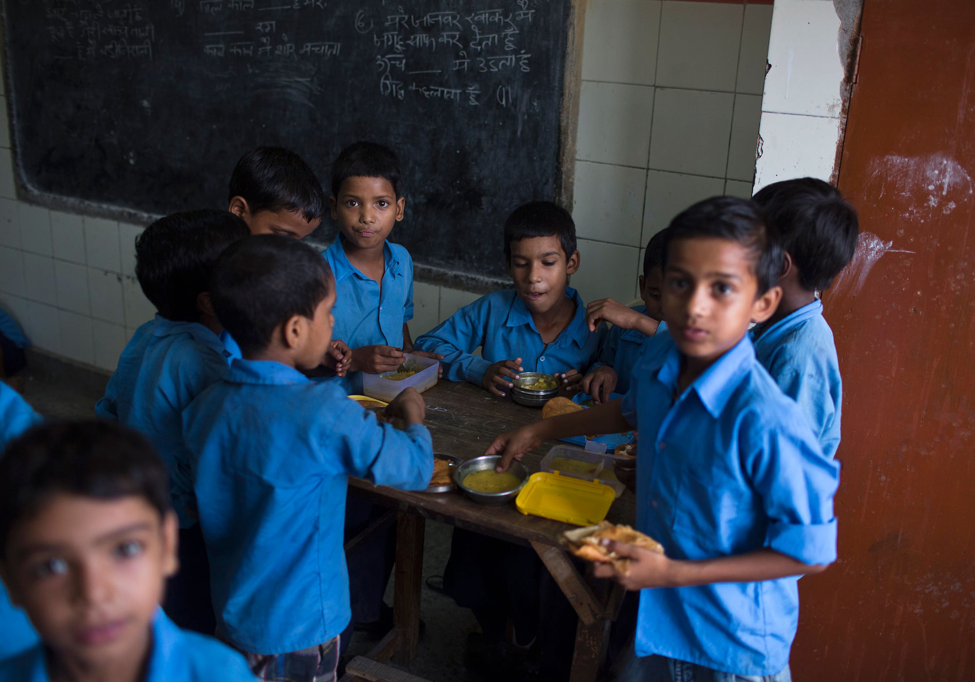 School boys eat their free mid-day meal, distributed by a government-run primary school, inside their classroom in New Delhi. (Photo: Reuters)