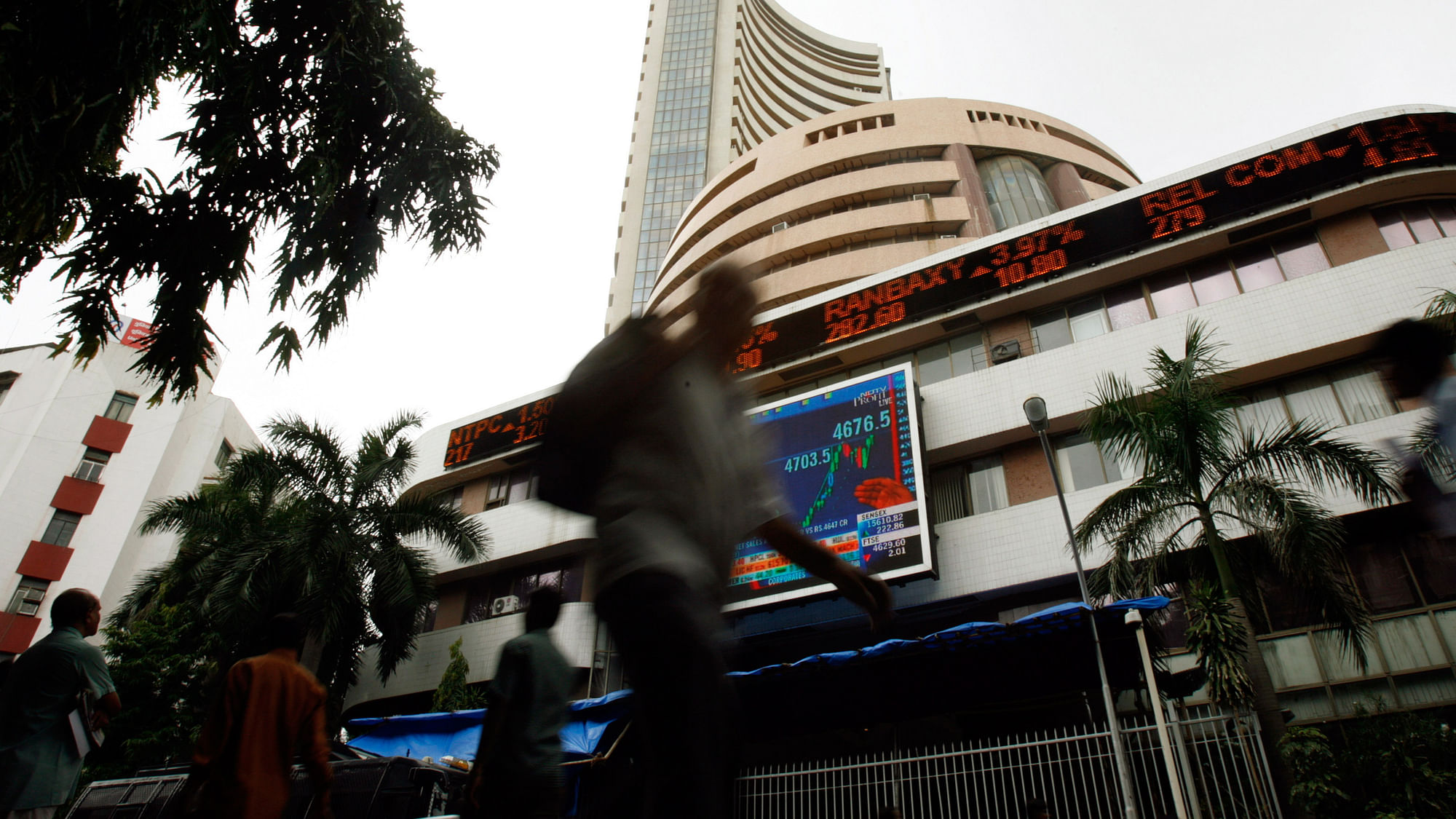 People walk pass the Bombay Stock Exchange (BSE) building displaying India’s benchmark share index on its facade, in Mumbai. (Photo: Reuters)