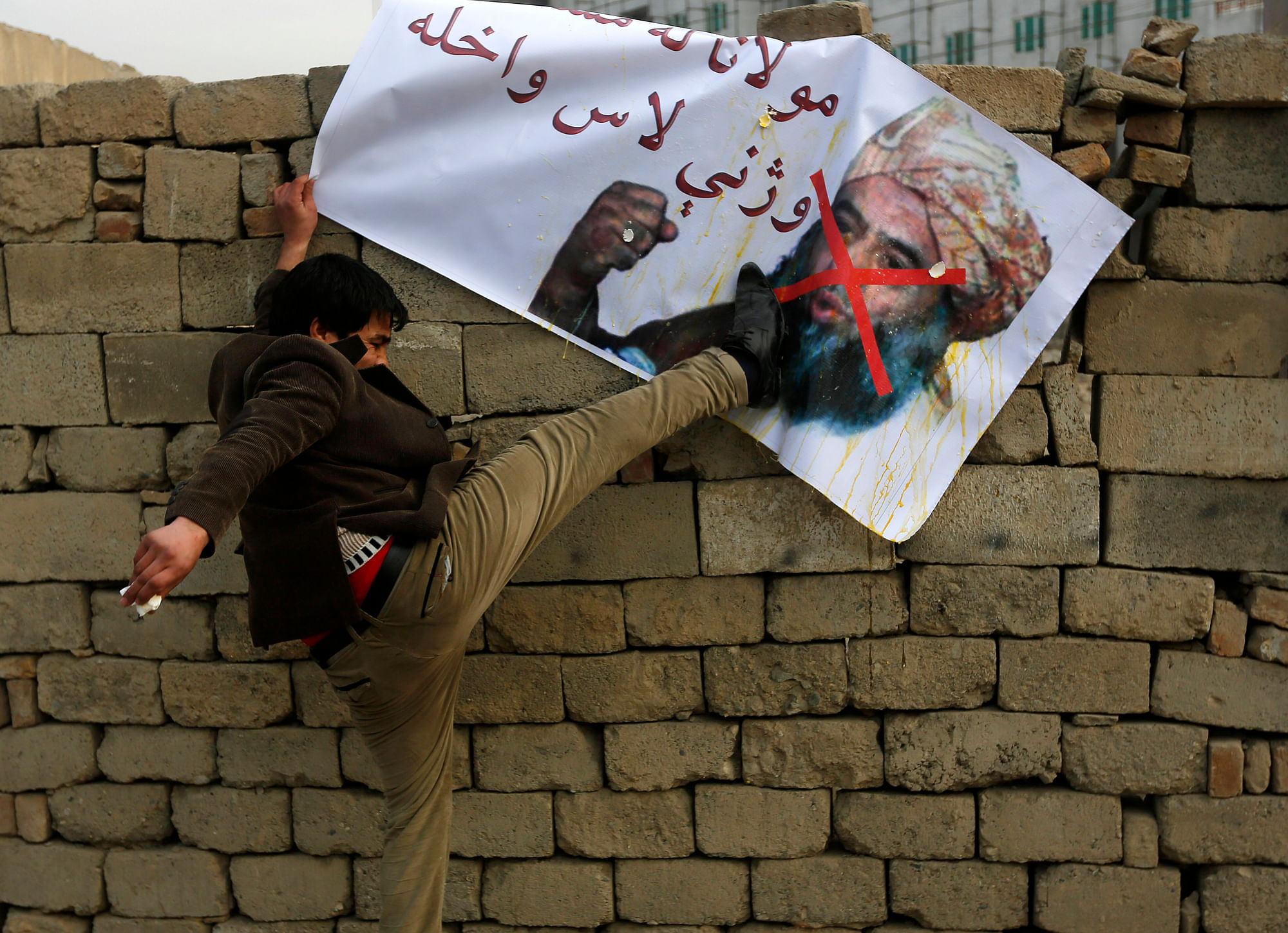 An Afghan man kicks a poster of Pakistani religious leader Maulana Fazlur Rehman during a demonstration against his visit in Kabul (Photo: Reuters)