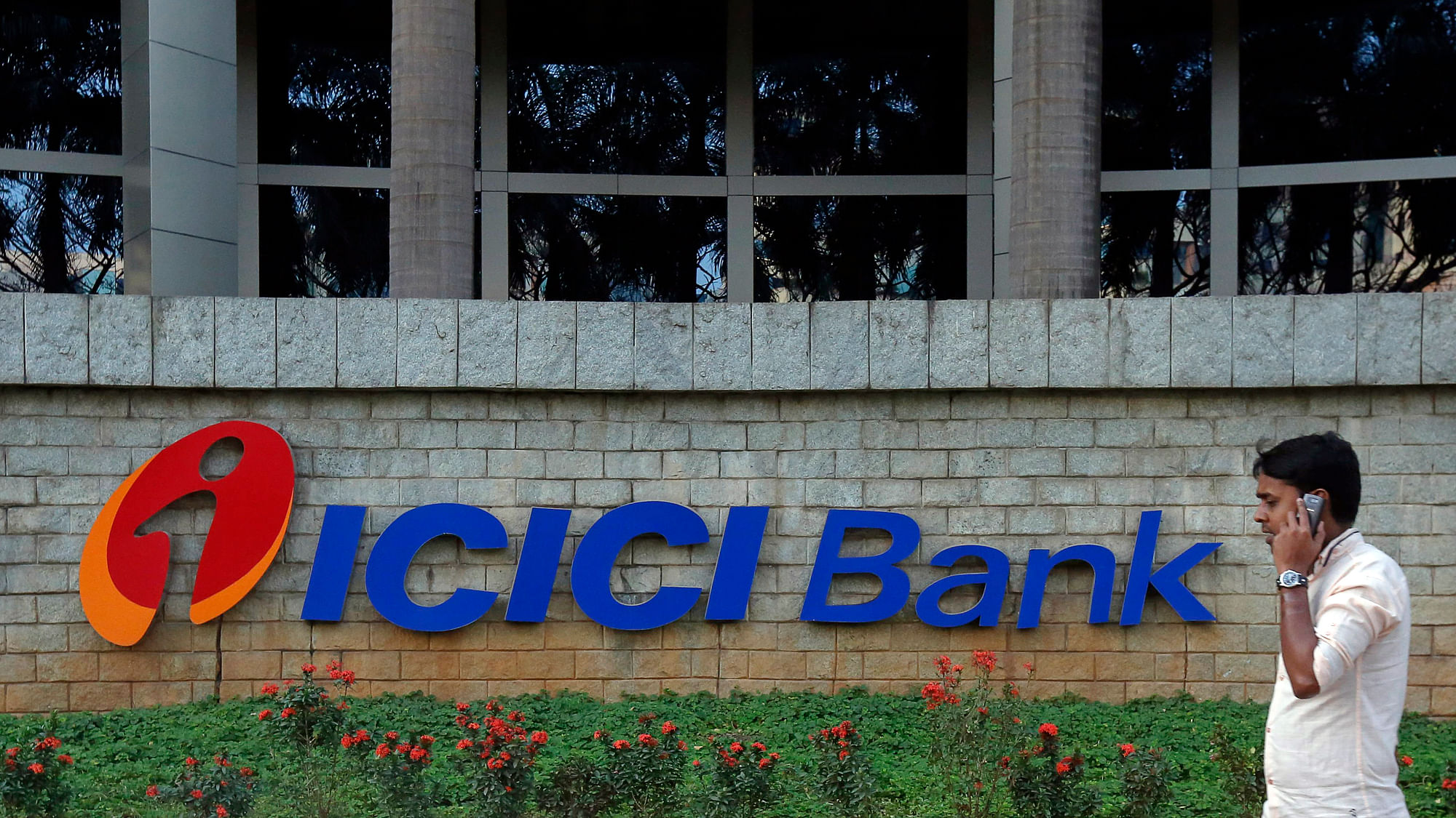 A pedestrian walks past a logo of ICICI Bank at its headquarters in Mumbai.&nbsp;