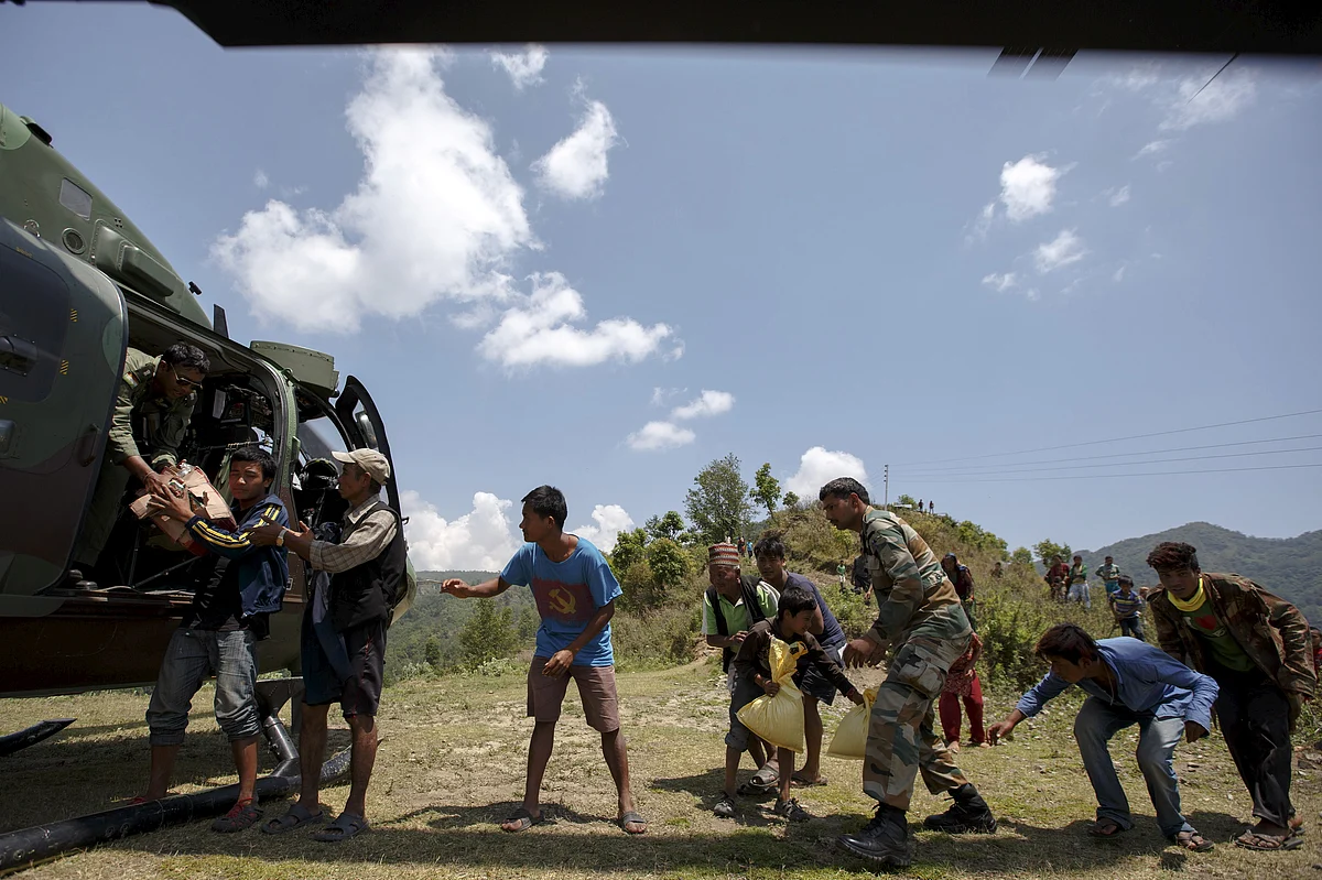 Indian military personnel and earthquake survivors unload relief supplies from an Indian Army helicopter near Sirdibas, Nepal, May, 2015. (Photo: Reuters)