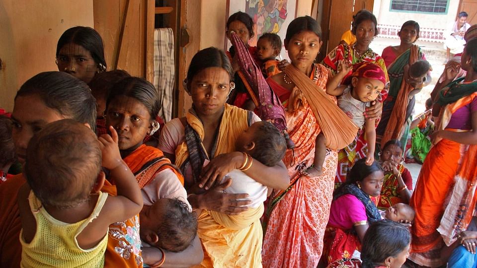 Tribal women wait with their children in Kandhamal, Odisha. (Photo: Reuters)