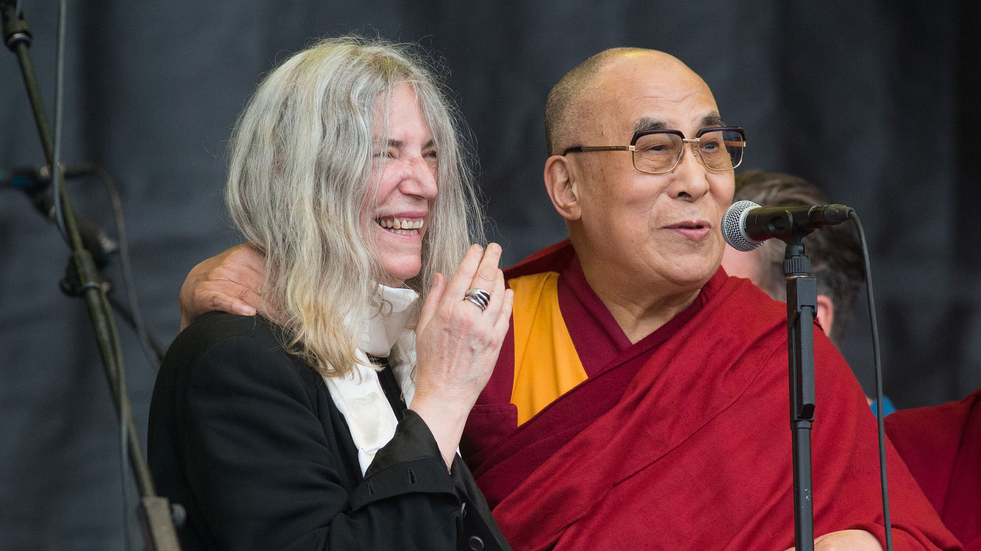 The Dalai Lama speaks to the crowd during singer Patti Smith’s, left, performance at the Glastonbury music festival. (Photo: AP)