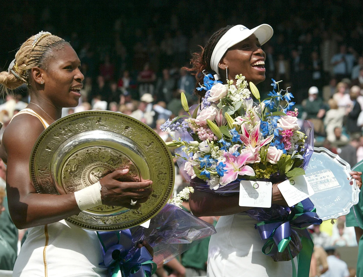 In this July 6, 2002 photo, Serena Williams, left, holds her trophy after defeating her sister Venu to win the Final. Following wins at the Australian and French Opens, Serena can become the fourth woman to win the calendar Grand Slam this year. Serena has to date won a totel of 20 Grand Slam singles titles. (Photo: AP)<a></a>