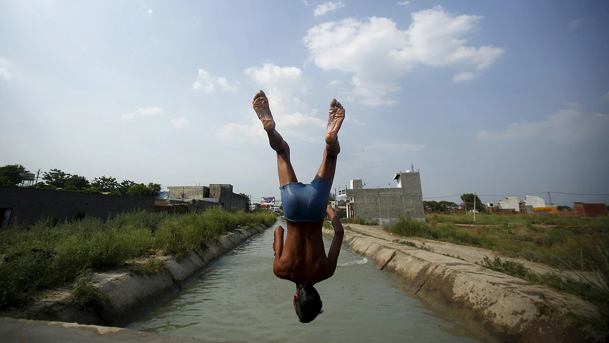 A boy jumps into a water canal to beat the heat in Ghaziabad, Uttar Pradesh, on Thursday. (Photo: Reuters/Anindito Mukherjee)