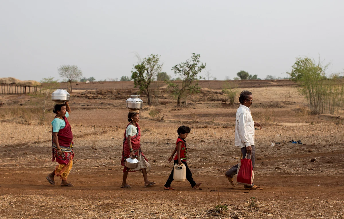 Bhaagi (L) and Sakhri (2nd from L), wives of Sakharam Bhagat (R) walk to fetch water from a well outside Denganmal village, Maharashtra, India, April 20, 2015. (Photo: Reuters)