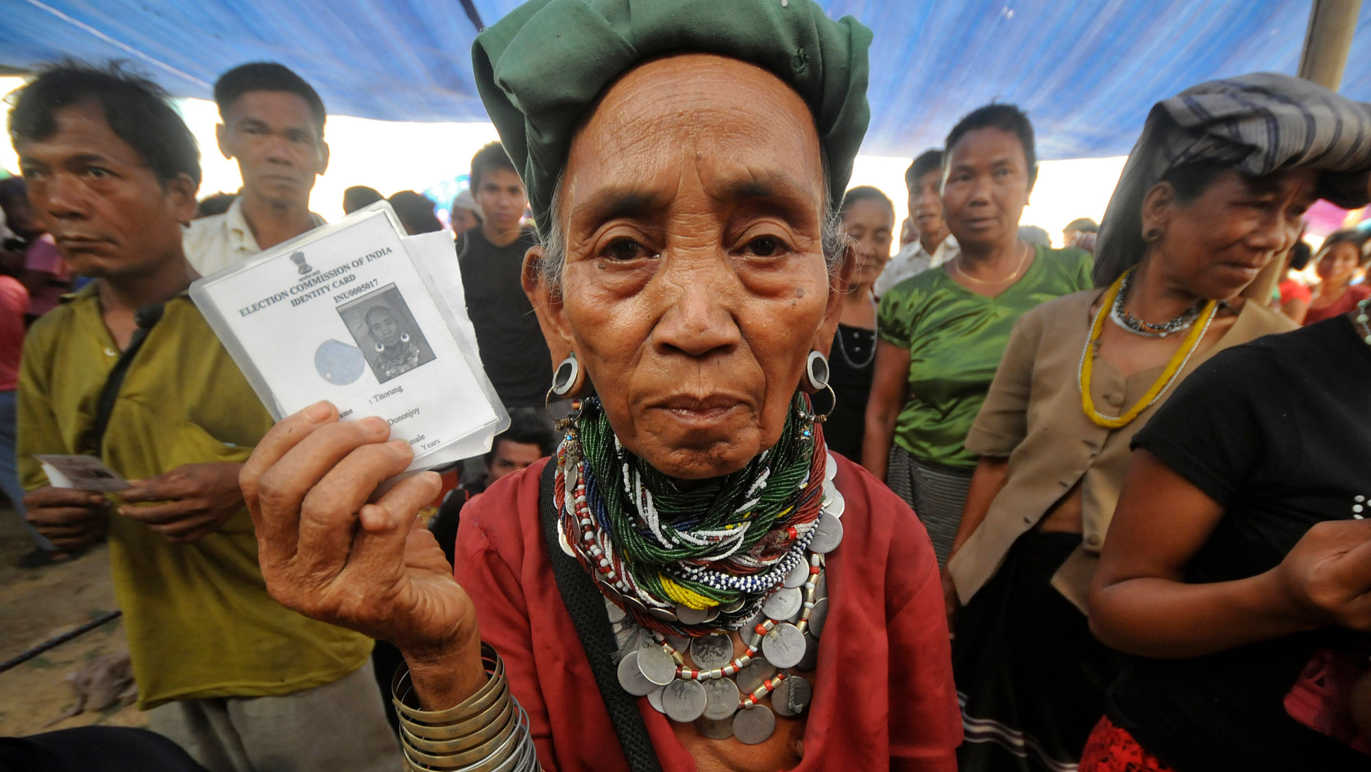 A Bru  refugee wearing traditional ornaments displays her voting card as she and others wait to cast their ballots at Thamsapara relief camp in  Tripura on&nbsp;April 1, 2014. (Photo: Reuters)