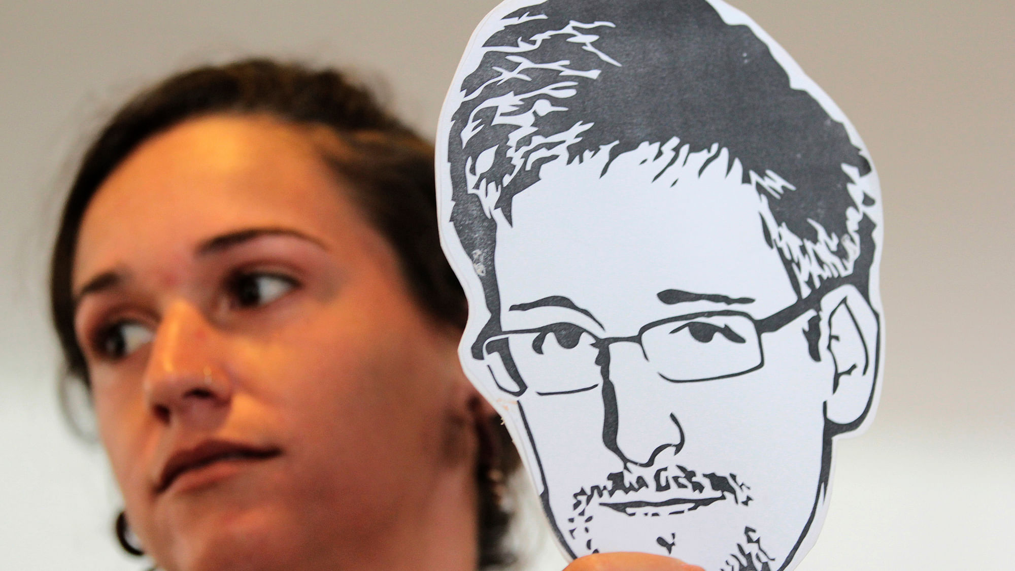 An activist from an advocacy group holds an illustration of whistleblower Edward Snowden. (Photo: Reuters)
