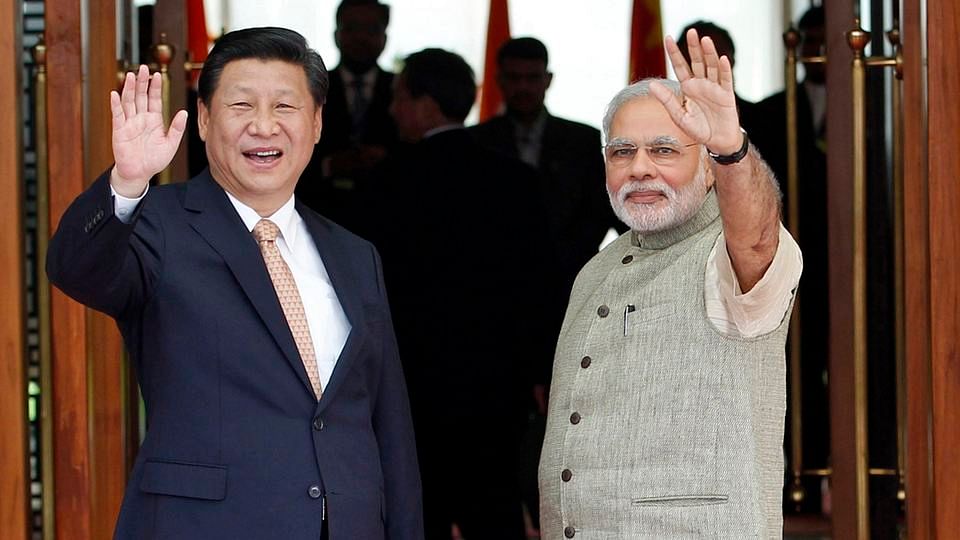 India’s Prime Minister Narendra Modi (R) and China’s President Xi Jinping wave to the media during a photo opportunity ahead of their meeting at Hyderabad House in New Delhi September 18, 2014. (Photo: Reuters)