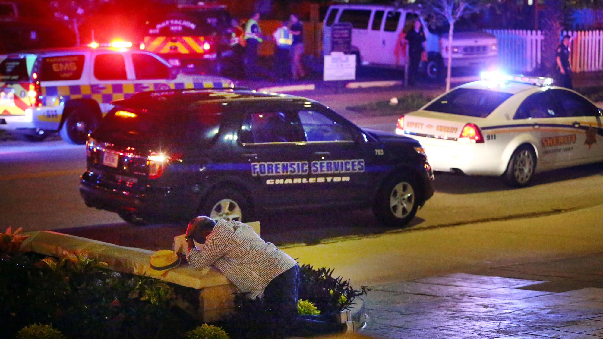 

A man kneels across the street from where police gather outside the Emanuel AME Church following a shooting on Wednesday. (Photo: AP)