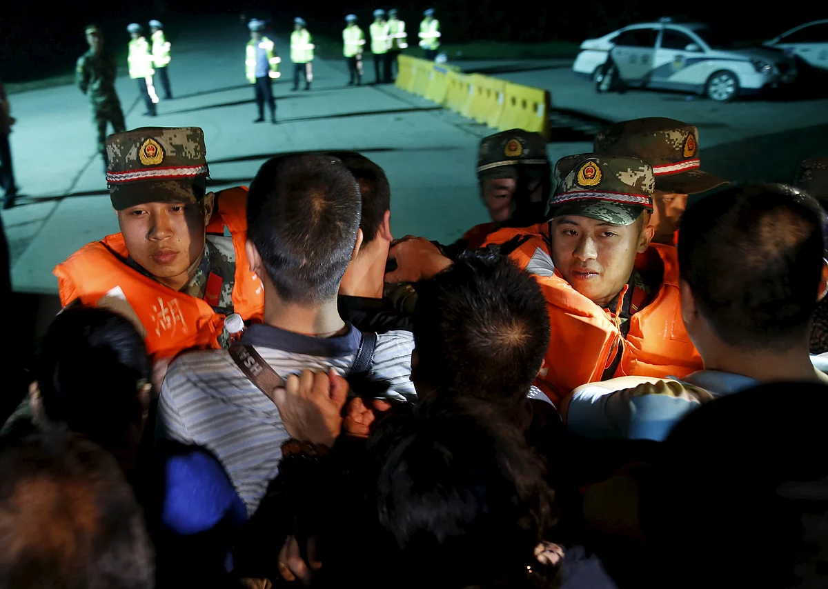 Family members of passengers of the Eastern Star push a cordon of paramilitary police as they march as they marched towards the site of the sunken cruise ship in the Yangtze River to demand news of missing relatives in the Jianli section of the Hubei province, China. (Photo: Reuters)