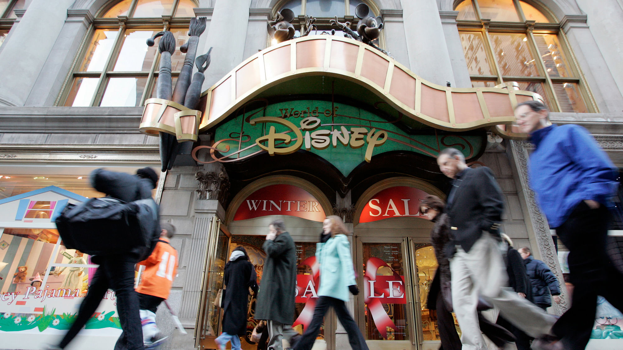 Passers-by walk in front of the World of Disney store in New York. (Photo: Reuters)