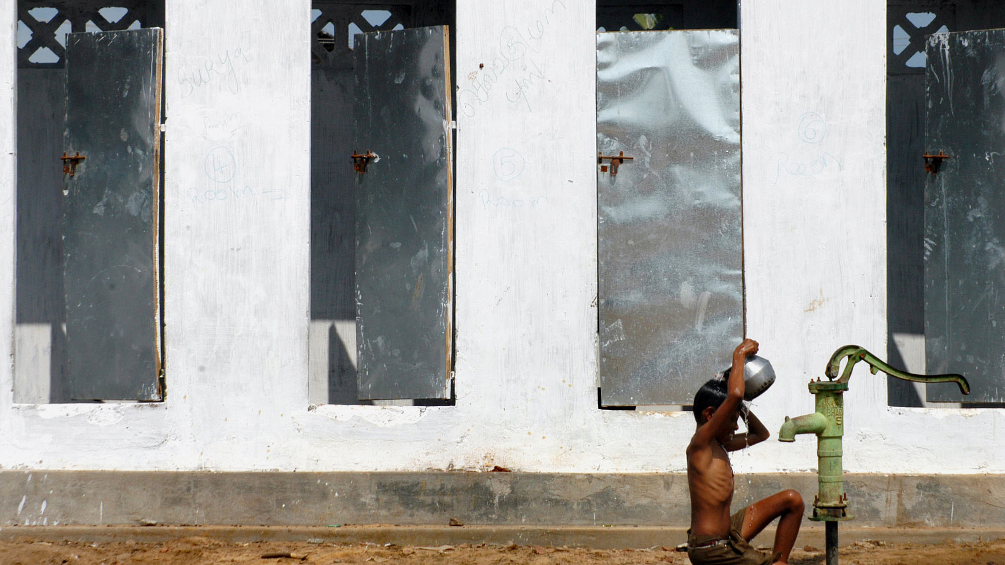 















 A boy takes bath outside newly built toilets in a village.&nbsp;
