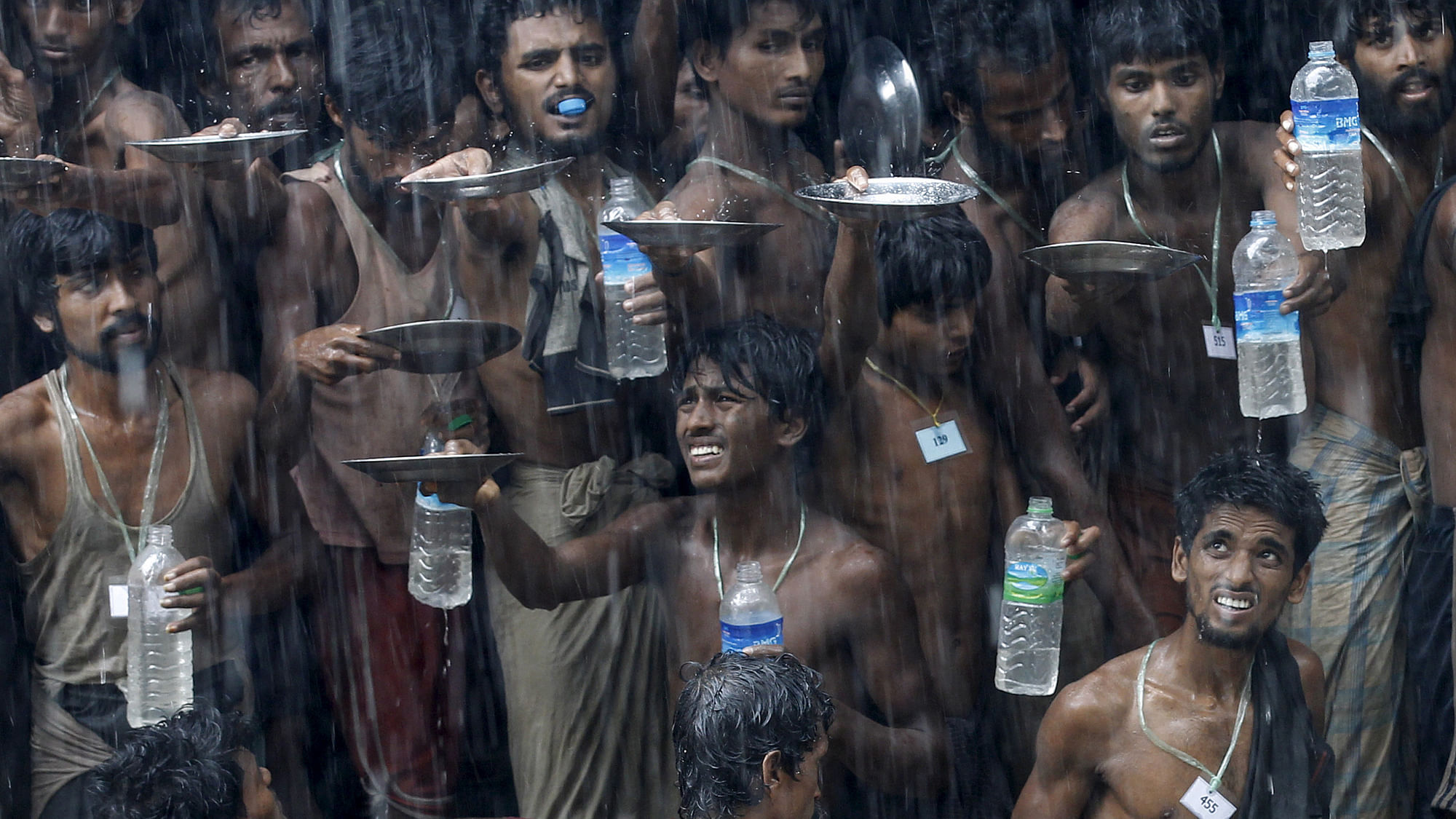 Migrants, who were found at sea on a boat, collect rainwater during a heavy rain fall at a temporary refuge camp near Kanyin Chaung jetty, outside Maungdaw township, northern Rakhine state, Myanmar June 4, 2015. (Photo: Reuters)&nbsp;