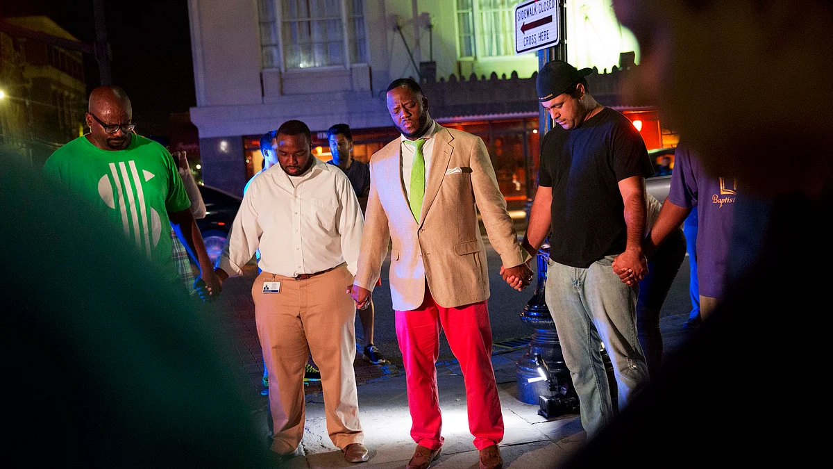 Worshippers gather to pray down the street from the Emanuel AME Church following a shooting. (Photo: AP)