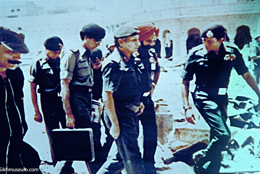 Indian Army officers, including then Major General Kuldeep Singh Brar (C), walk through the debris inside the temple complex on 6 June 1984. (Photo: SikhMuseum.com)