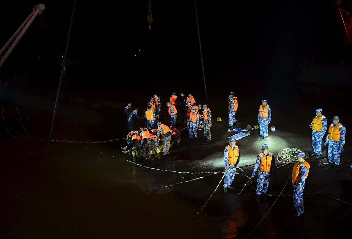 Rescue workers carry the body of a victim at the site of the sinking of the Eastern Star in the Yangtze River, Hubei province, China. (Photo: Reuters)