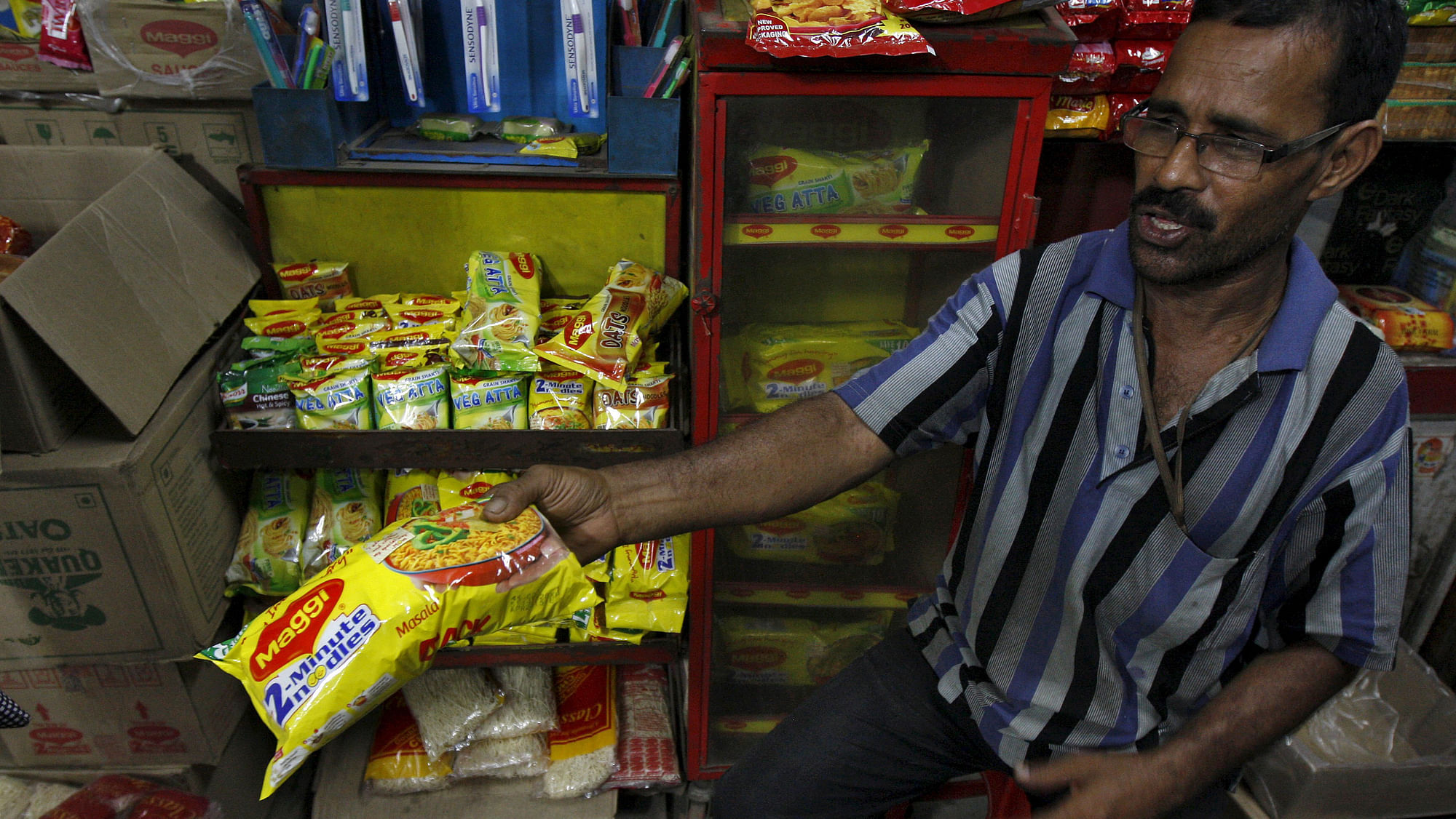A vendor hands out&nbsp;a packet of Maggi noodles. (Photo: Reuters)