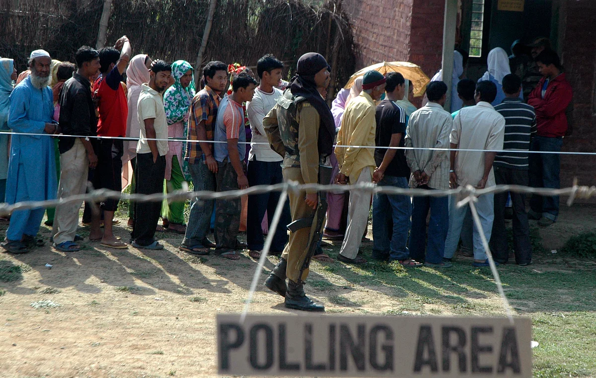 A Border Security Force soldier keeps vigil as voters wait in a queue to cast their ballots outside a polling station in Manipur. (Photo: Reuters) 