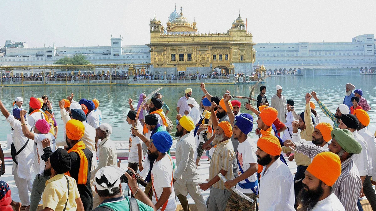 Sikh youth brandishing swords at the Golden temple. (Photo: PTI)