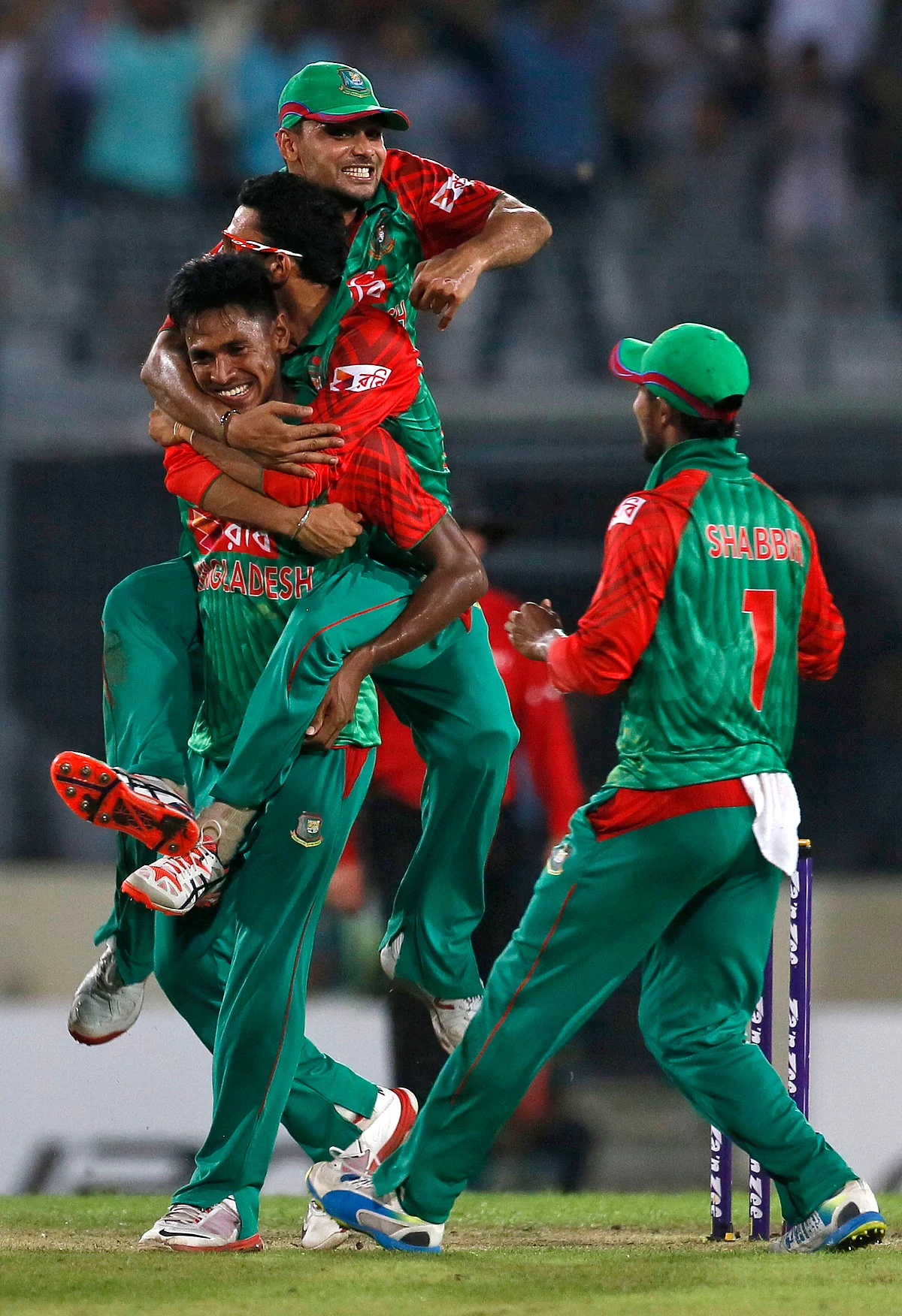 Bangladesh’s Nasir Hossain, top, and captain Mashrafe Mortaza, center, jumps on Mustafizur Rahman as they celebrate the dismissal of Ravindra Jadeja. (Photo: AP)