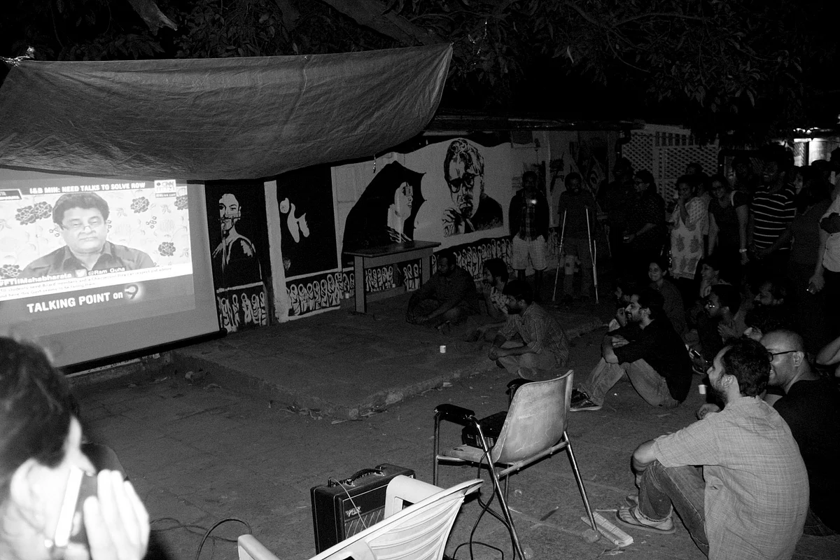 Students catch the latest news and hear Gajendra Chauhan speaking on a news channel with the help of a projector installed on the campus ground (Photo: <span style="font-size: 14.0000400543213px; line-height: 17.9999923706055px;">Facebook/FTIIWisdomTree)</span>