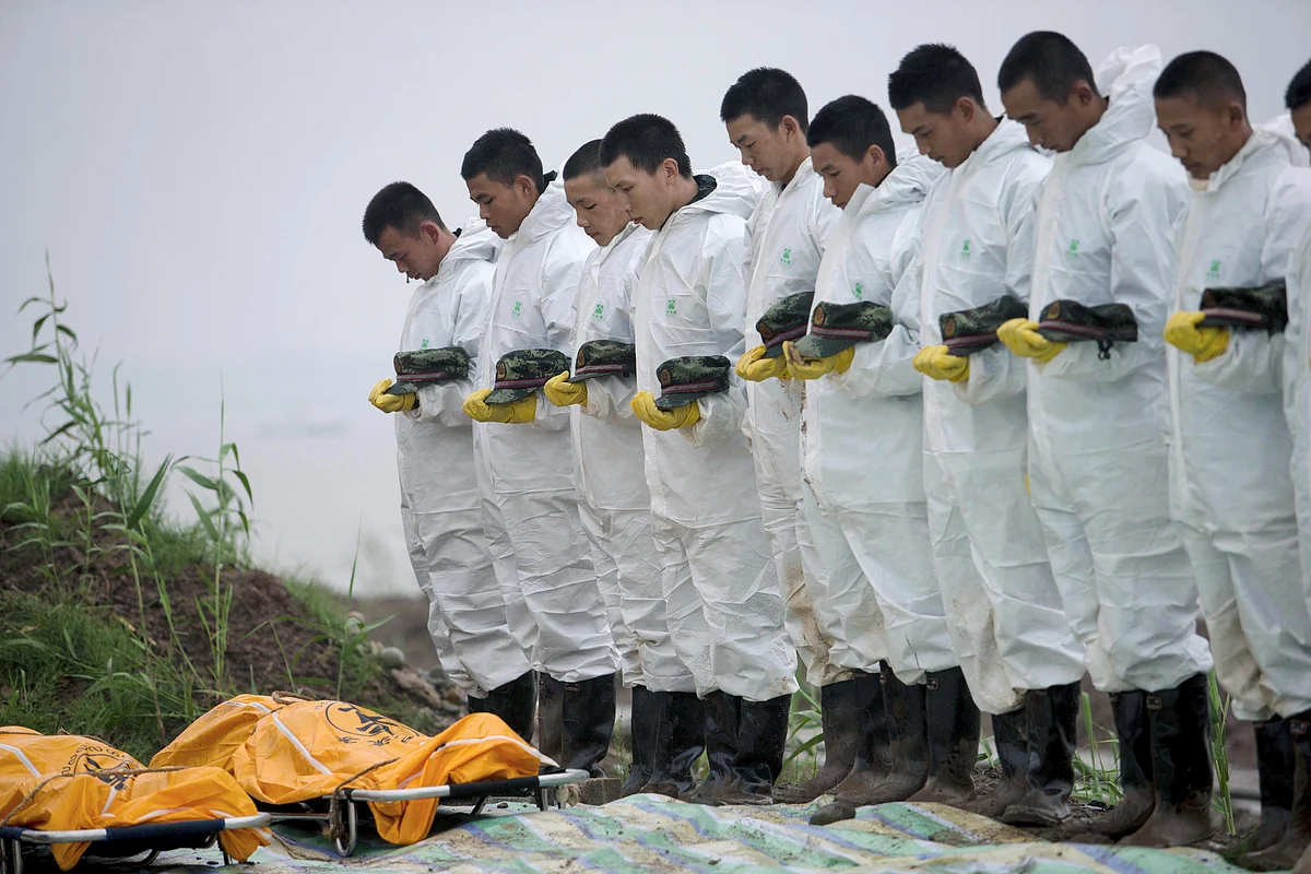 Rescue workers pay respects to the deceased after the Eastern Star, a cruise ship sank at the Jianli section of the Yangtze River, in China. (Photo: Reuters)